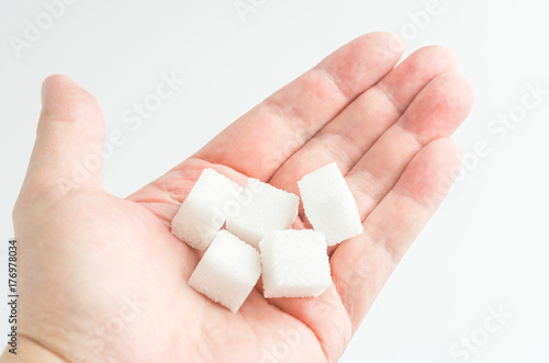 Sugar cubes in the hand, white background
