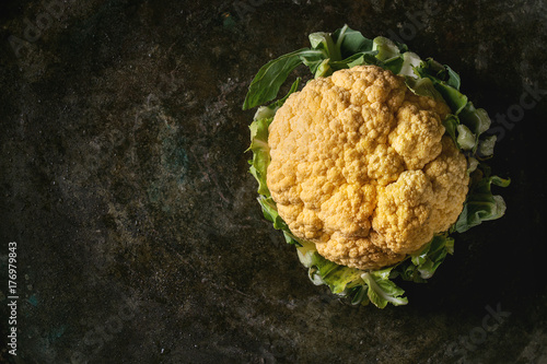 Fresh raw yellow organic cauliflower, cabbage romanesco over dark texture background. Top view with space. Healthy eating concept