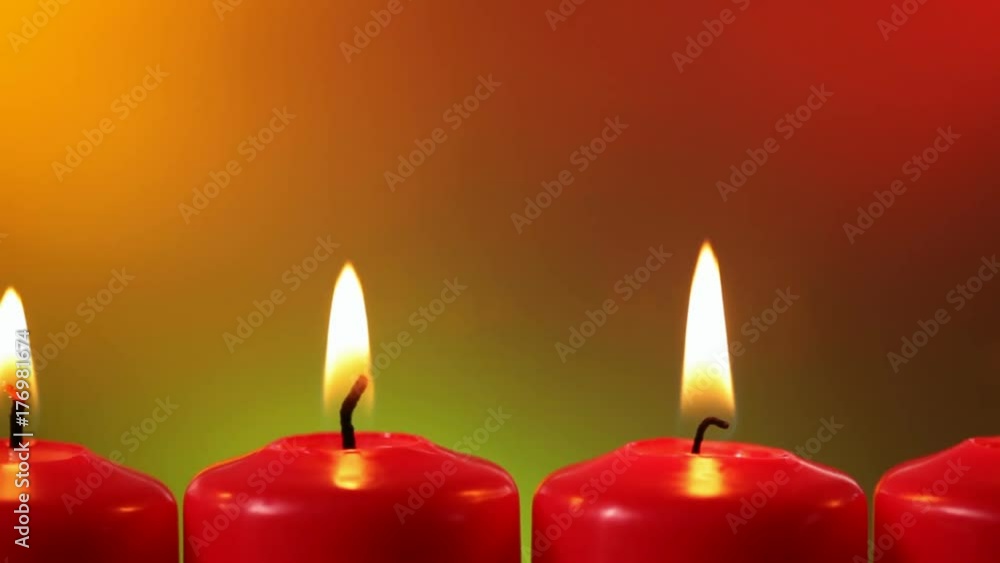 Closeup sliding in front of burning red christmas candles against smooth and warm colored blurry background - copyspace Closeup sliding in front of burning red christmas candles against smooth and warm colored blurry background - copyspace