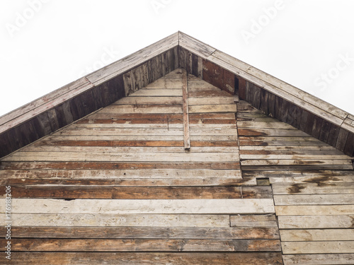 The front of the house, the ridge of the roof. Wooden background