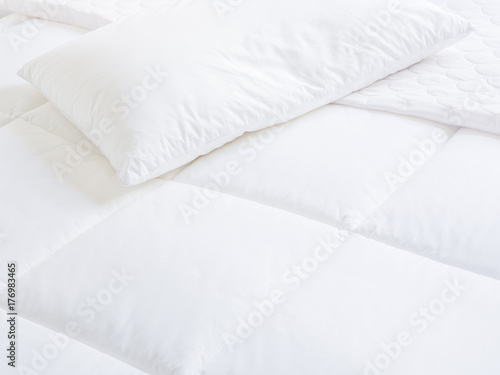 Closeup of white pillow and topper bed.