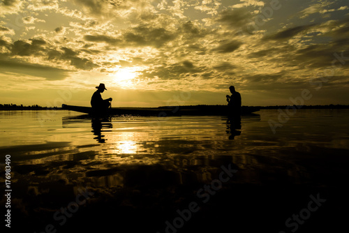 Silhouette of Fishermen with sunset time at Wanon Niwat district Sakon Nakhon Northeast Thailand. © Joeahead