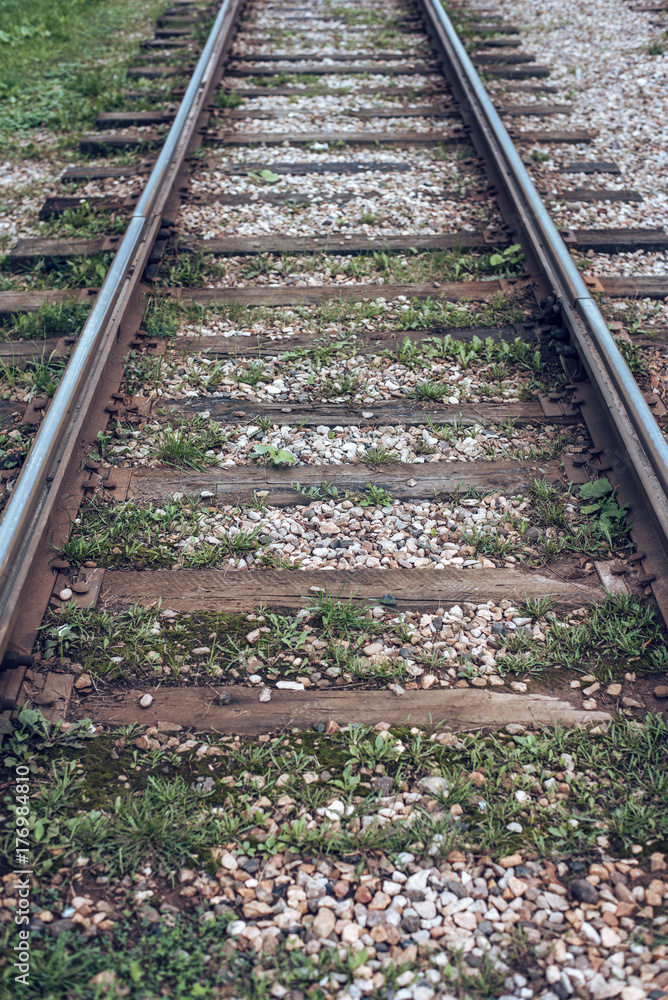 Old tram rails, close-up, summer autumn, between sleepers grass, gravel and stones in the city. Old tram rails, close-up, summer autumn, between sleepers grass, gravel and stones in the city.