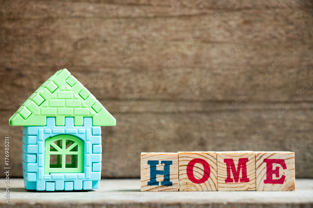 Puzzle model in home shape with block in home wording on wood background