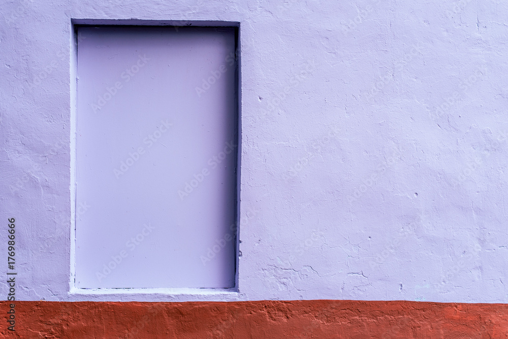 Fototapeta premium The homogeneous background of the wall is dyed with a brown and purple paint. Hidden window. The background of the concrete fence.
