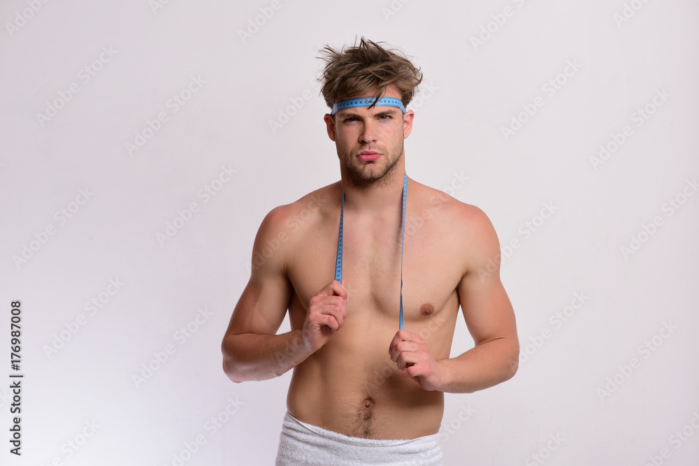 Fototapeta premium Man with confident face and measuring tape on naked torso