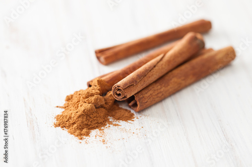Cinnamon sticks and ground cinnamon on a white wooden table