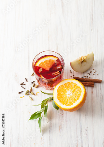 A glass of mulled wine and a half orange and a slice of Apple