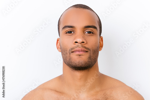 Hygiene, vitality, beauty, men life concept. Close up portrait of afro young nude guy with stubble isolated on pure white background, harsh and virile