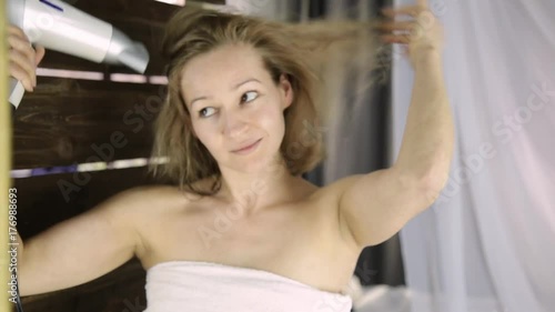 Young woman in towel drying her hair in front of a mirror. Skin care and home Spa photo