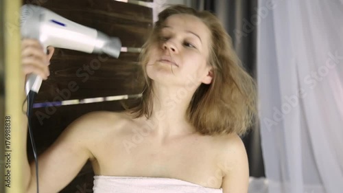 Young woman in towel drying her hair in front of a mirror. Skin care and home Spa photo