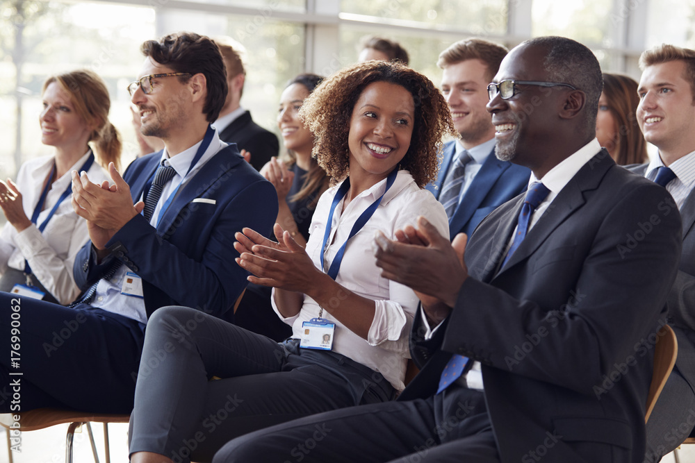 Smiling audience applauding at a business seminar