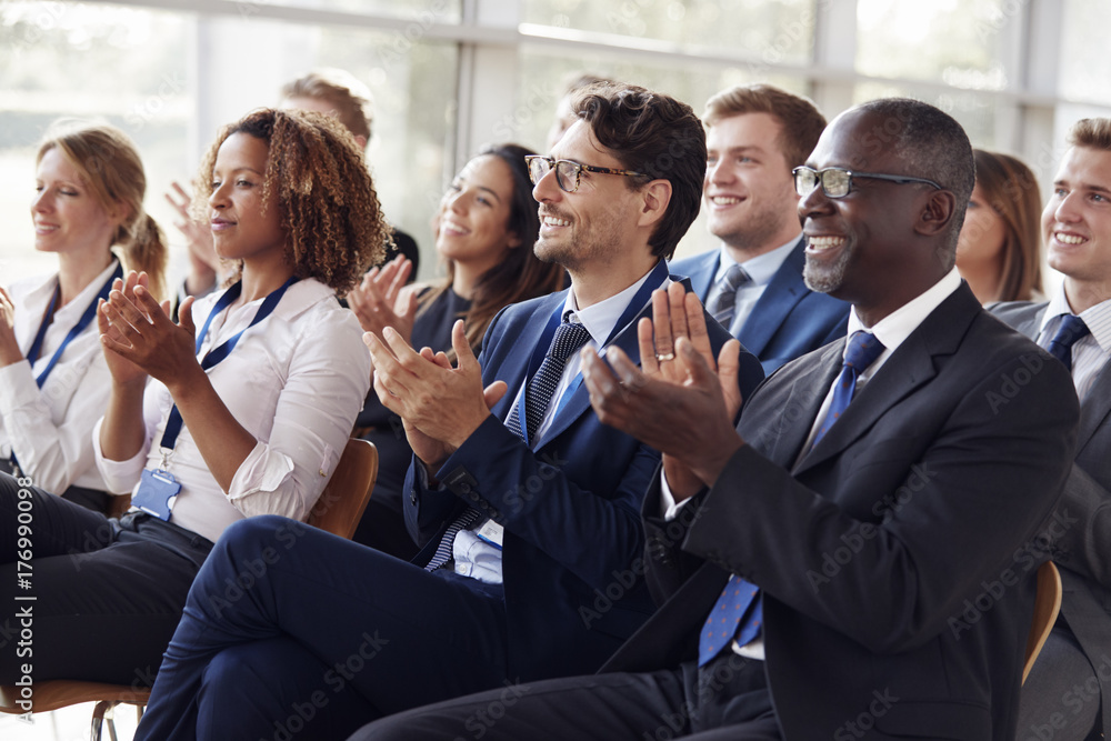 Smiling audience applauding at a business seminar Smiling audience applauding at a business seminar