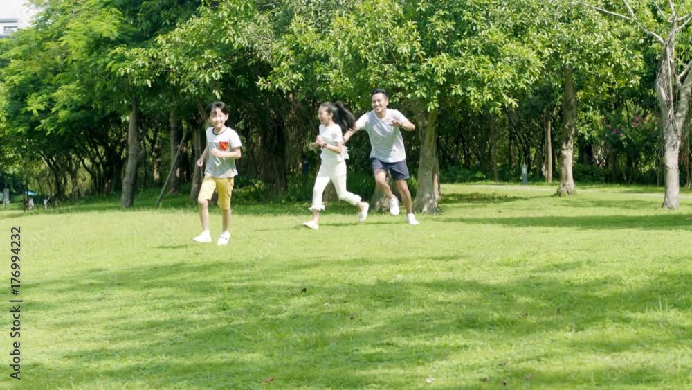 asian father playing chase game with his son & daughter in park in slow motion asian father playing chase game with his son & daughter in park in slow motion