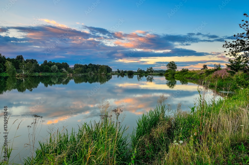 Beautiful summer landscape. Pond in the countryside in fabulous evening colors.