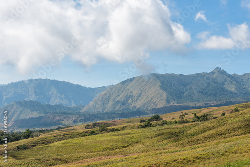 Mountain and savannah field with low cloud over hill. Rinjani mountain, Lombok island, Indonesia.
