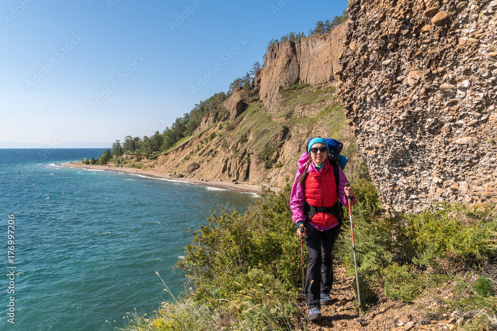 A tourist walks along a dangerous path over a cliff