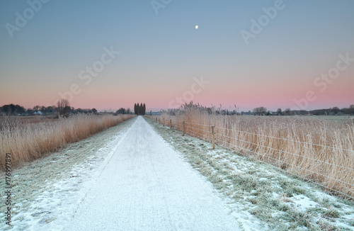 countryside road in snow at sunrise