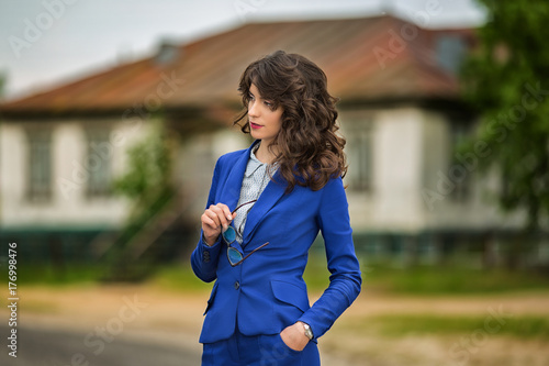 Fototapeta Naklejka Na Ścianę i Meble -  Business woman in a business suit with glasses in hand
