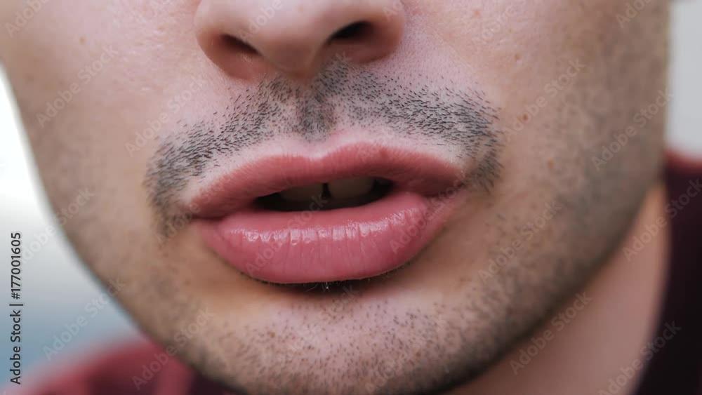 Close up on the mouth of a young man talking to the camera Close up on the mouth of a young man talking to the camera