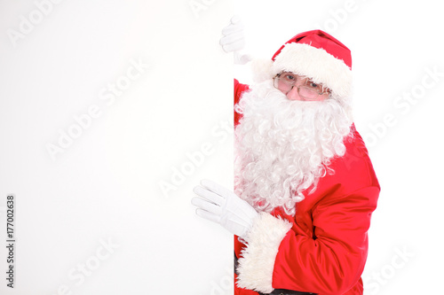 Kind Santa Claus pointing in white blank sign, isolated on white background