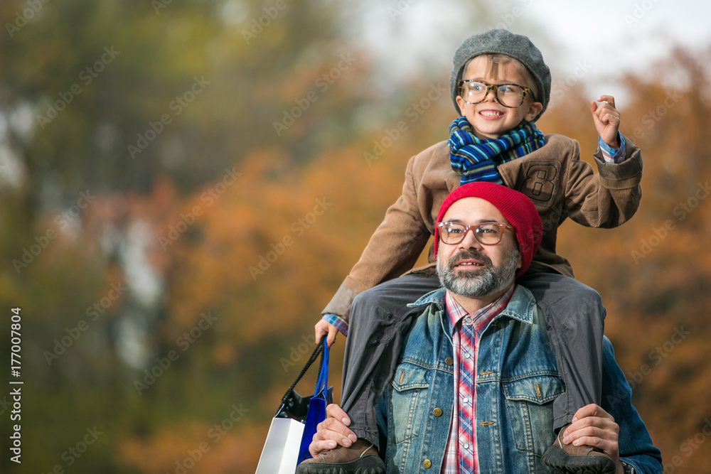 Father and son playing in the park in autumn scenery Father and son playing in the park in autumn scenery