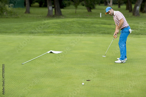 Man playing golf on a sunny...