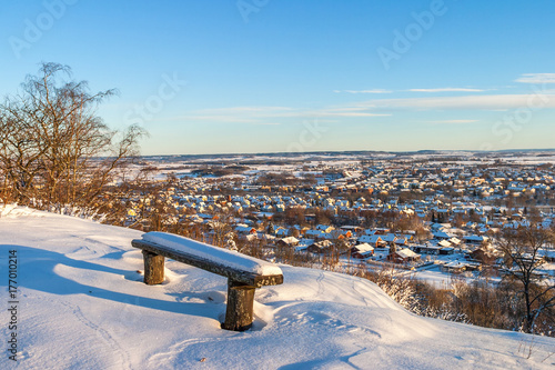 Snowed park bench with a view of the city photo