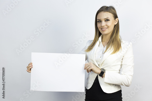 Girl with sheet of paper A3. Business girl holding a clean sheet of paper A3. Write your text, advertise your services.