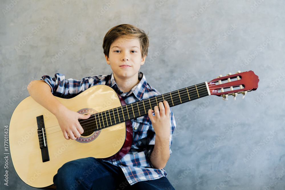 Fototapeta premium Teen boy playing acoustic guitar