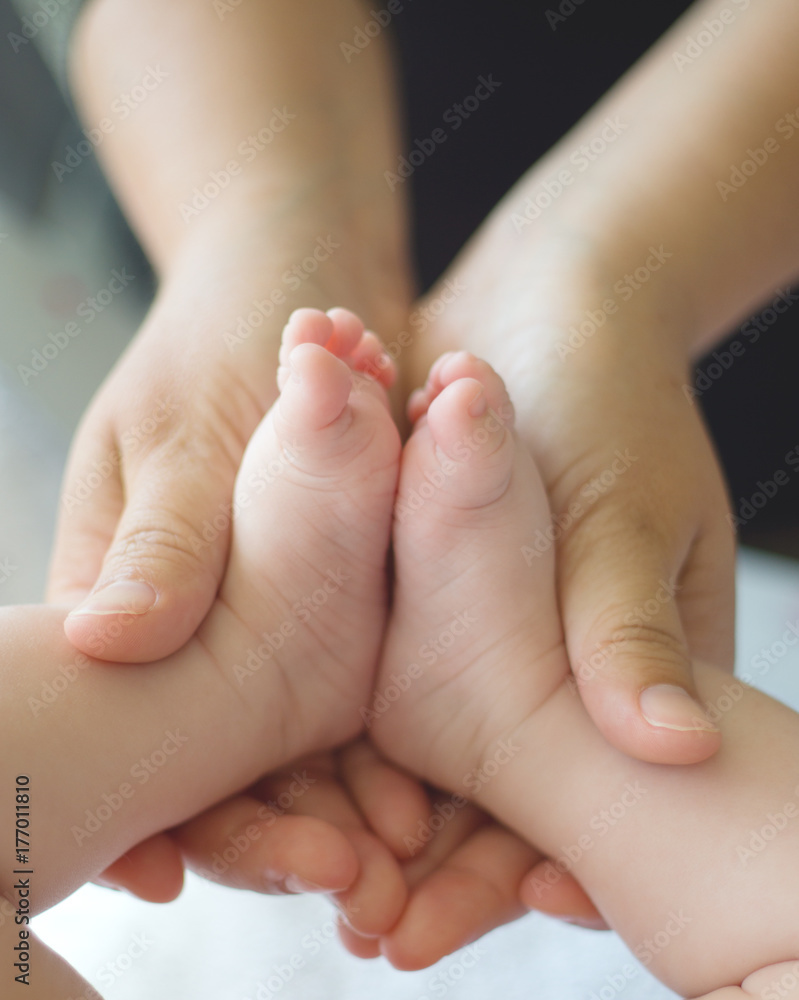 Mother holding the feet of her baby Mother holding the feet of her baby