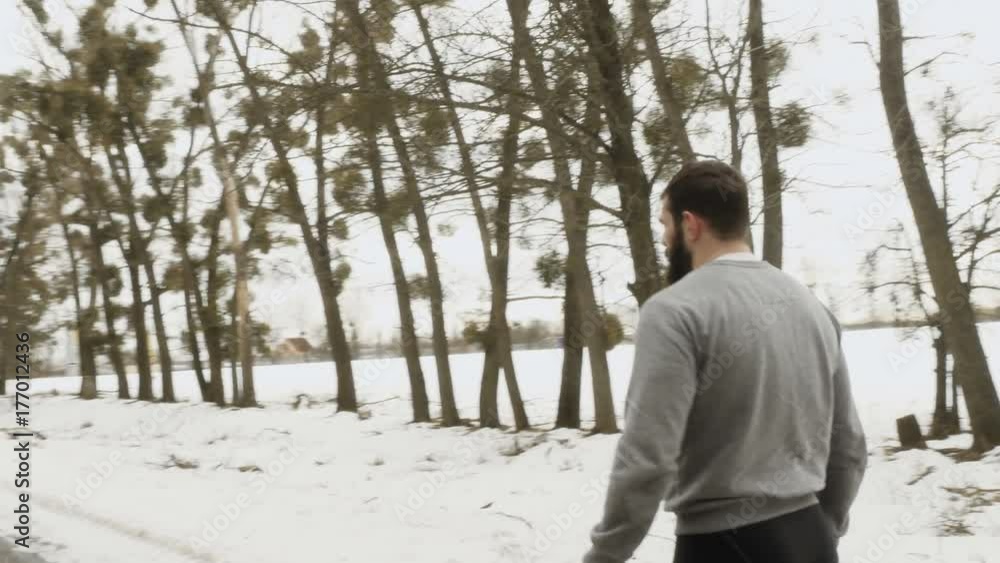Bearded man adjusts himself for a run along the winter road Bearded man adjusts himself for a run along the winter road