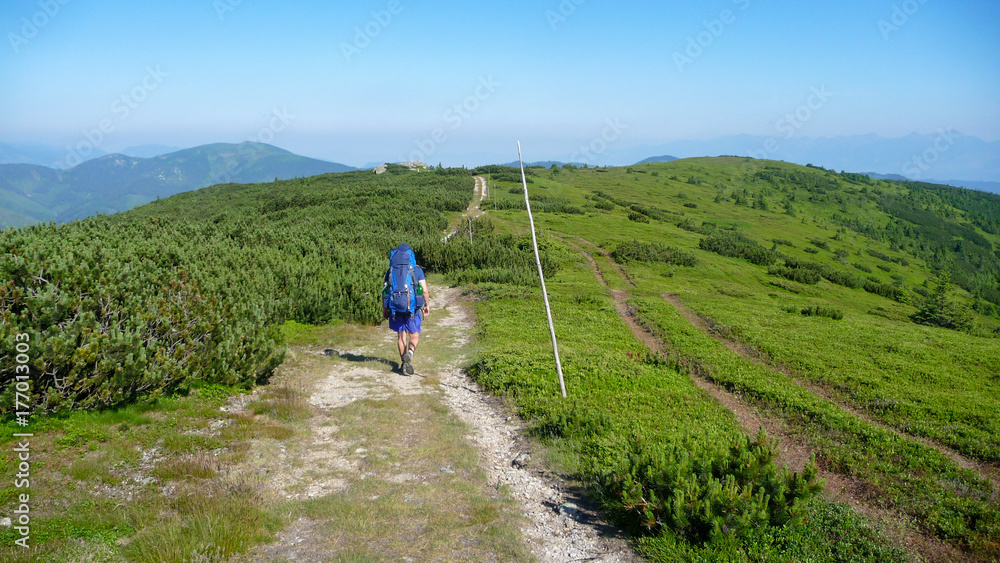 Man hiking in mountains with big bag