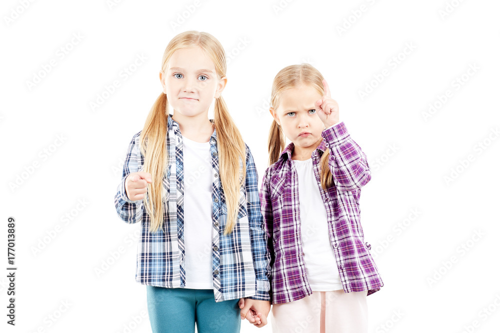 Portrait of cute little sisters in checked shirts posing on white background Portrait of cute little sisters in checked shirts posing on white background