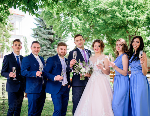 Newlyweds and their friends pose with glasses of champagne in the garden