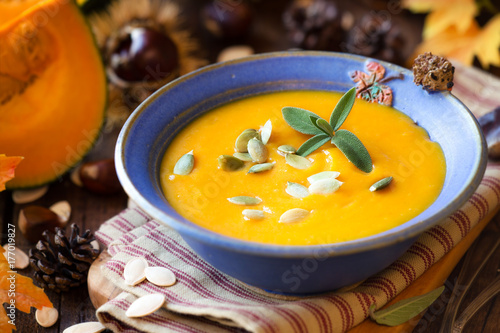 Creamy Pumpkin soup or squash soup with garnished with pumpkin seeds and sage leaves