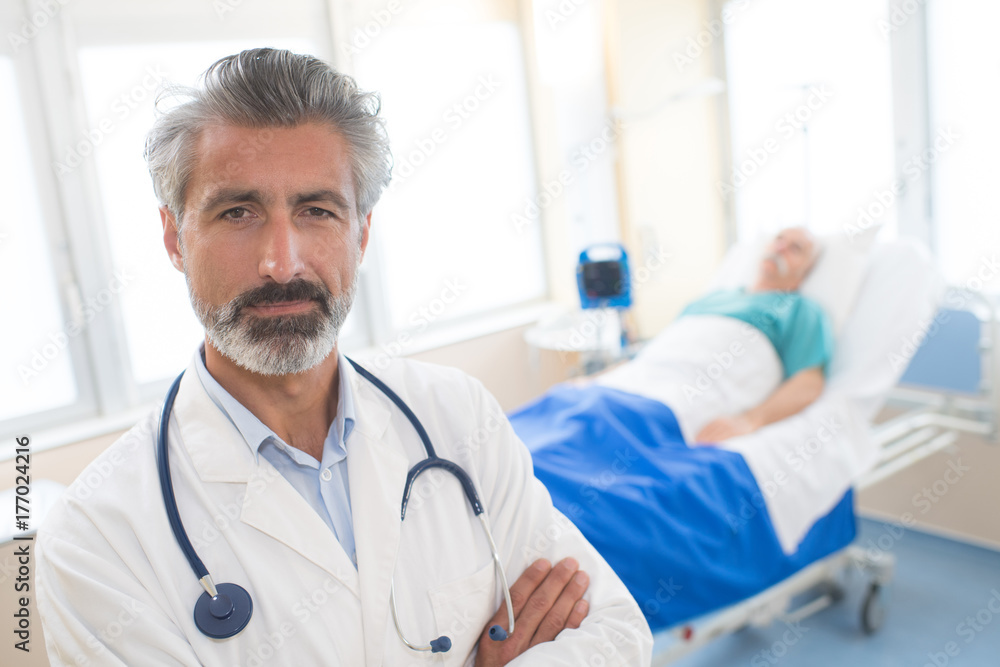 portrait of doctor with patient in bed in background portrait of doctor with patient in bed in background