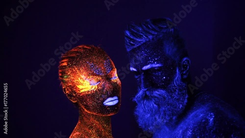 Portrait of a bearded man and woman painted in ultraviolet powder photo