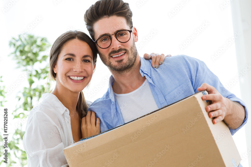Beautiful young couple moving at new home. Beautiful young couple moving at new home.