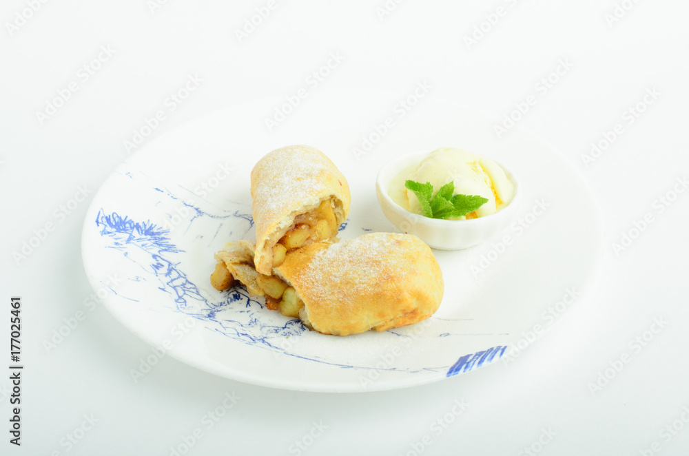 Apple strudel with ice cream decorated mint on a plate isolated on white background Apple strudel with ice cream decorated mint on a plate isolated on white background