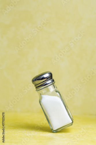 Salt shaker balanced on its edge