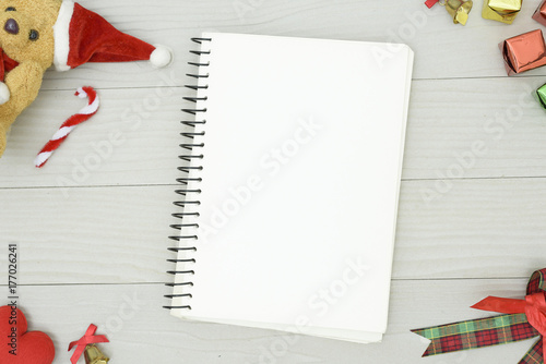 Christmas bear and white book with top view and copy space on the white wooden table. Christmas holiday concept.