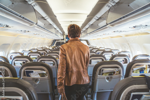 Woman walking down the aisle of an airplane