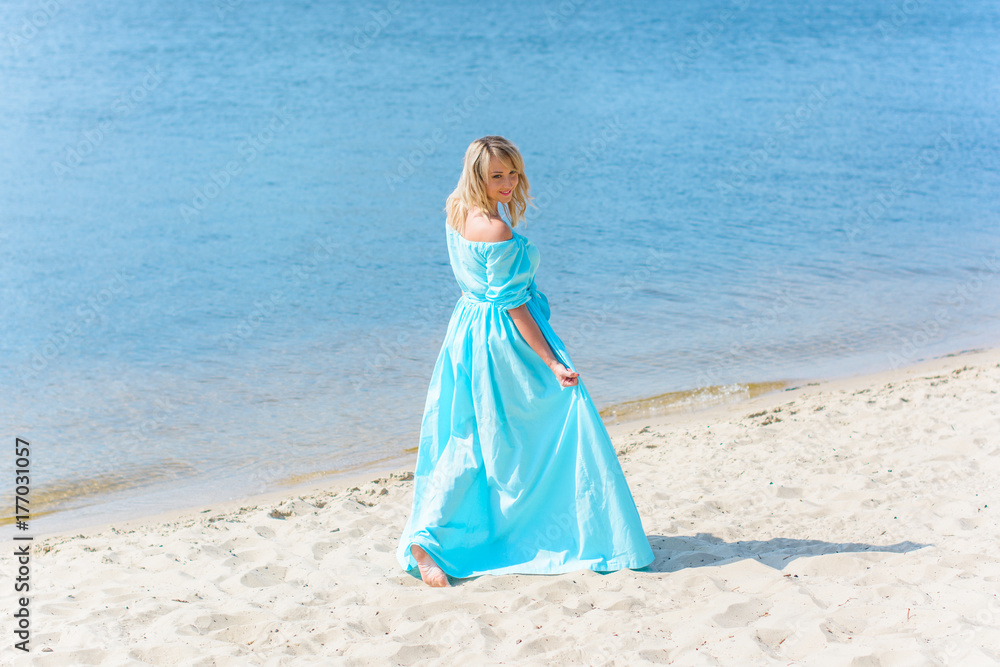 A middle-aged woman, plus in a light blue dress, rests on a city waterfront on a day off. The concept of femininity and romance in the city bustle A middle-aged woman, plus in a light blue dress, rests on a city waterfront on a day off. The concept of femininity and romance in the city bustle