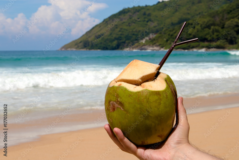 Coconut in hand on background of tropical beach. Coconut in hand on background of tropical beach.