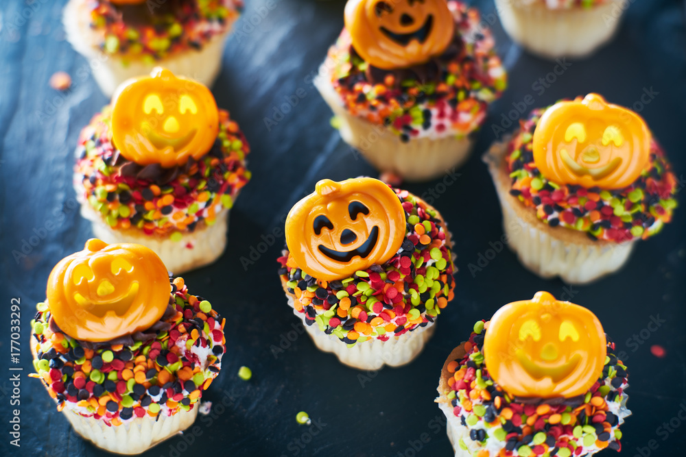 festive halloween pumpkin cupcakes with chocolate frosting and colorful sprinkles