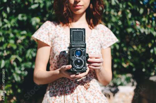Mid section of woman holding a vintage camera photo