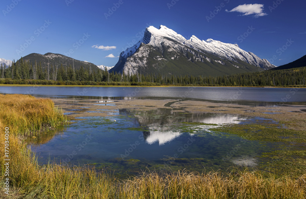 Snowy Rundle Mountain Top reflected in blue water of Vermillion Lakes Landscape on crisp Autumn Day in Banff National Park, Rocky Mountains Alberta Canada