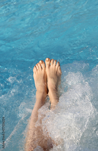 barefoot feet of a young woman during the whirlpool in the pool