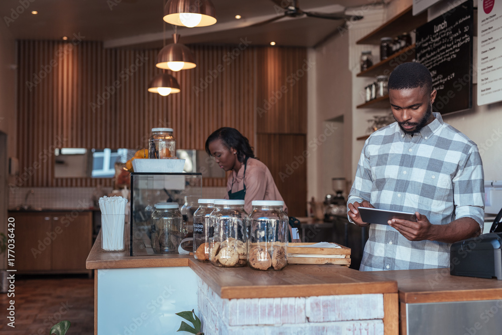 Two African entrepreneurs busy working at their cafe counter Two African entrepreneurs busy working at their cafe counter